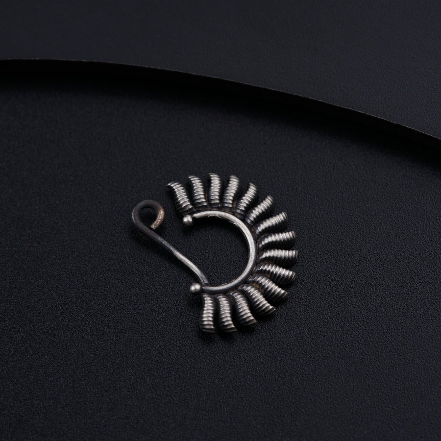 a small metal object on a black surface