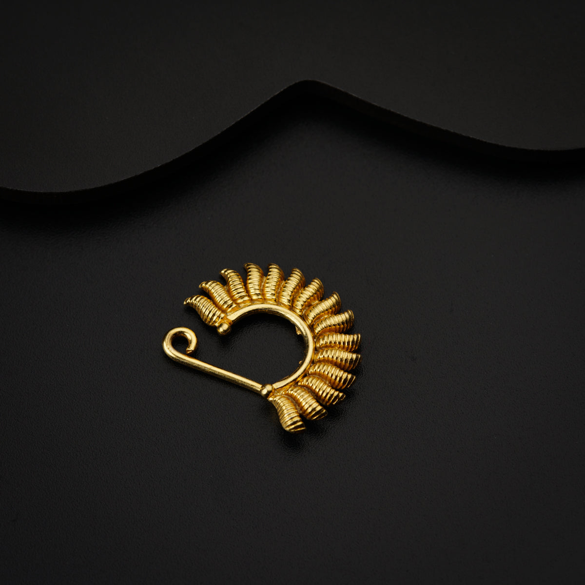 a gold brooch with a black background
