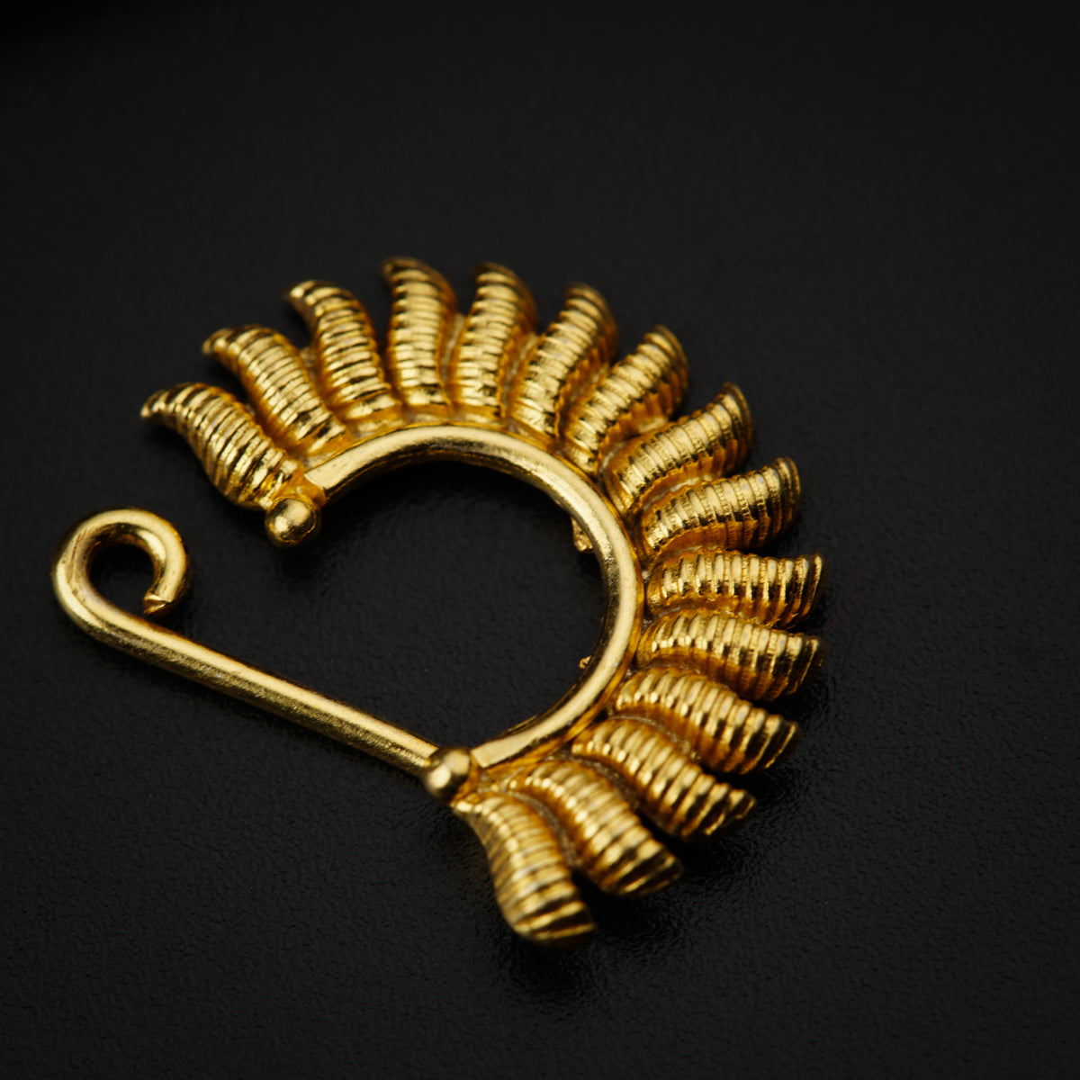 a gold brooch with a leaf design on it