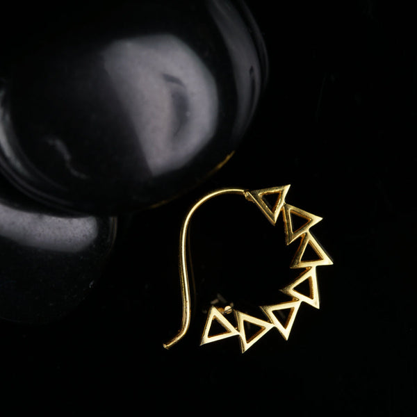 a pair of earrings sitting on top of a black surface
