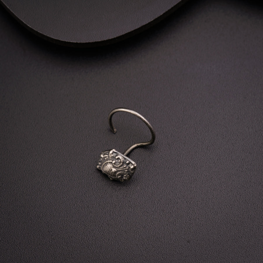 a pair of silver earrings sitting on top of a table