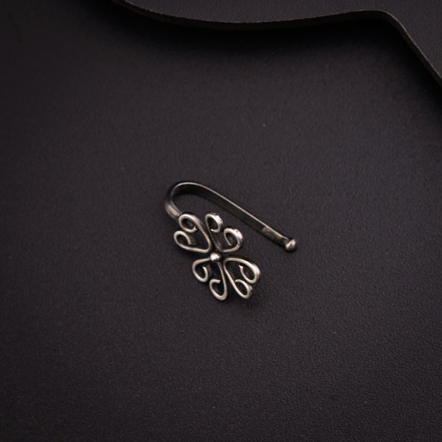 a pair of earrings sitting on top of a black surface