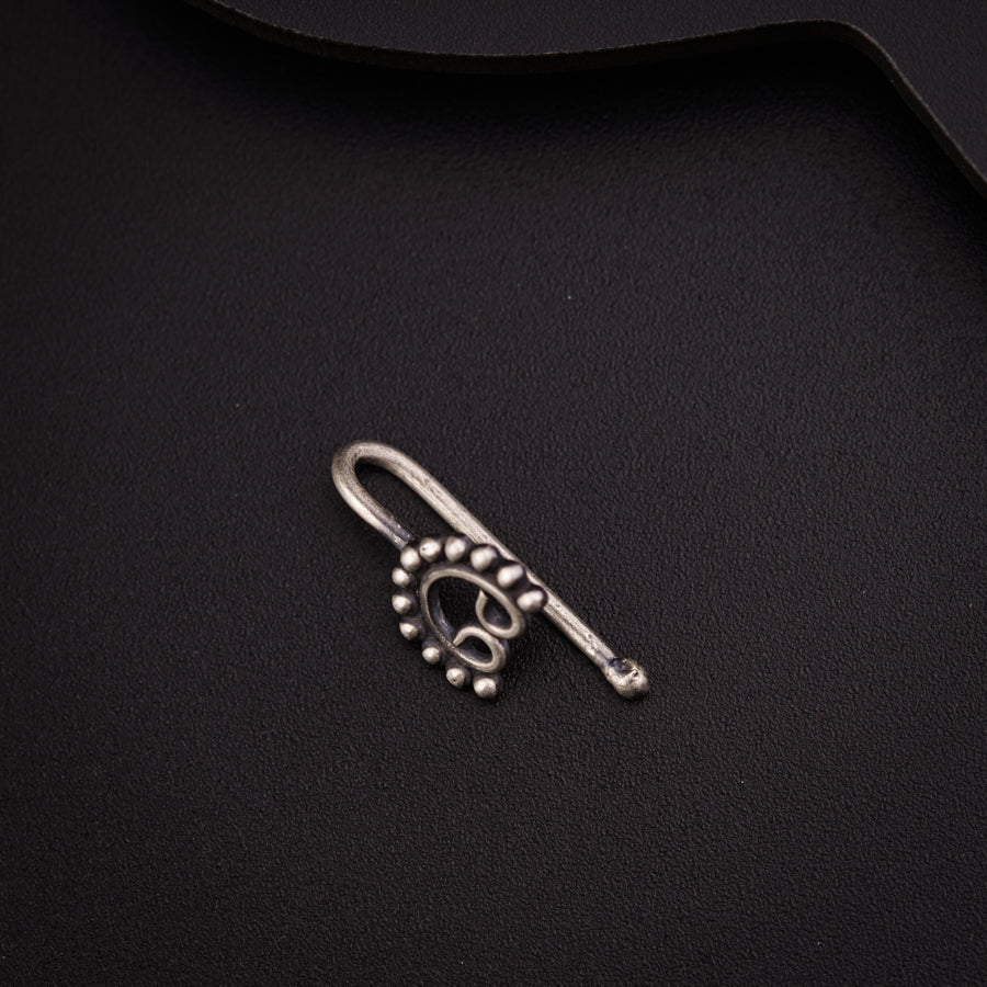 a metal hook with a skull on it on a black surface