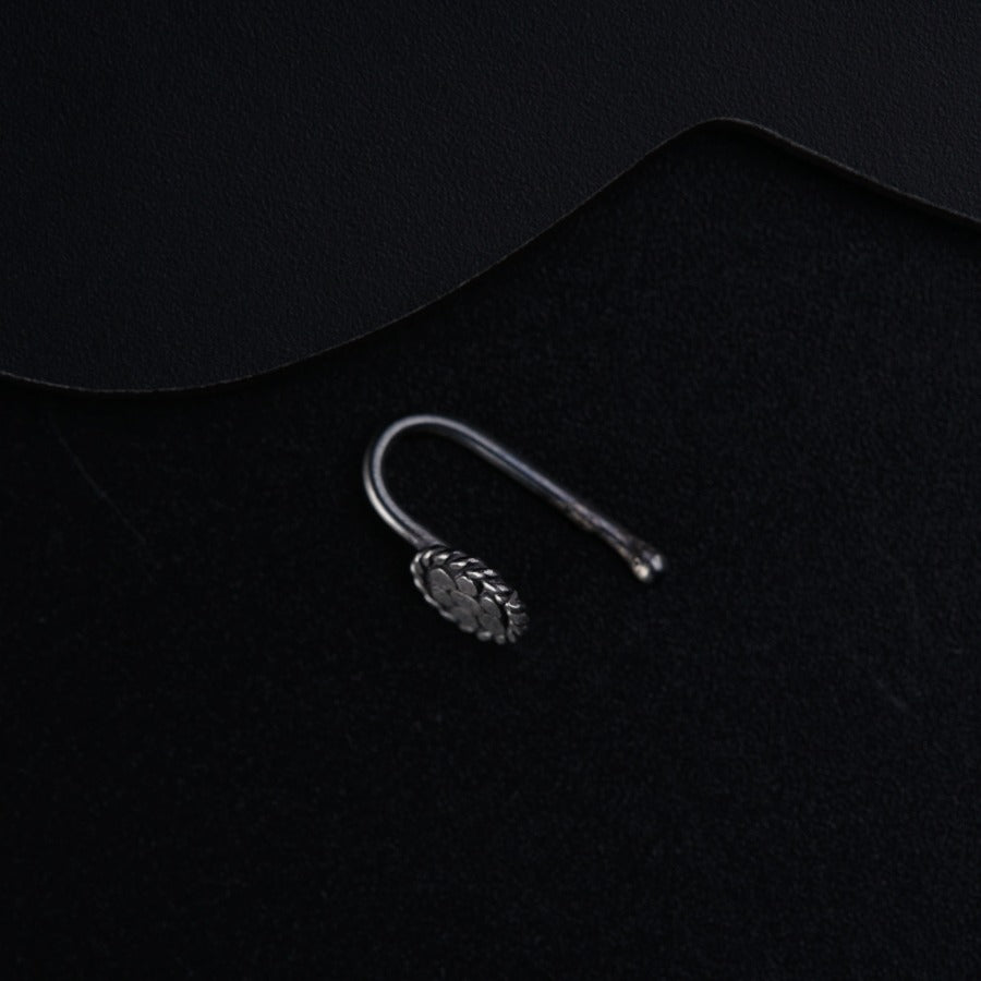a pair of earrings sitting on top of a black surface