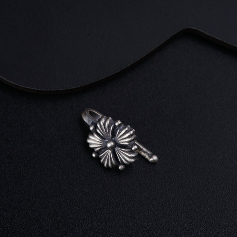a pair of earrings sitting on top of a black surface