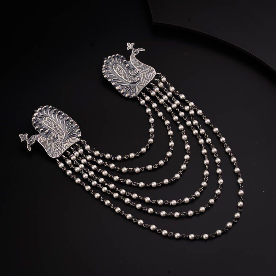 a necklace with pearls and a bird on it