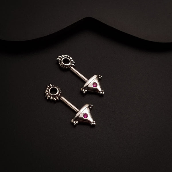 a pair of silver earrings with a red stone