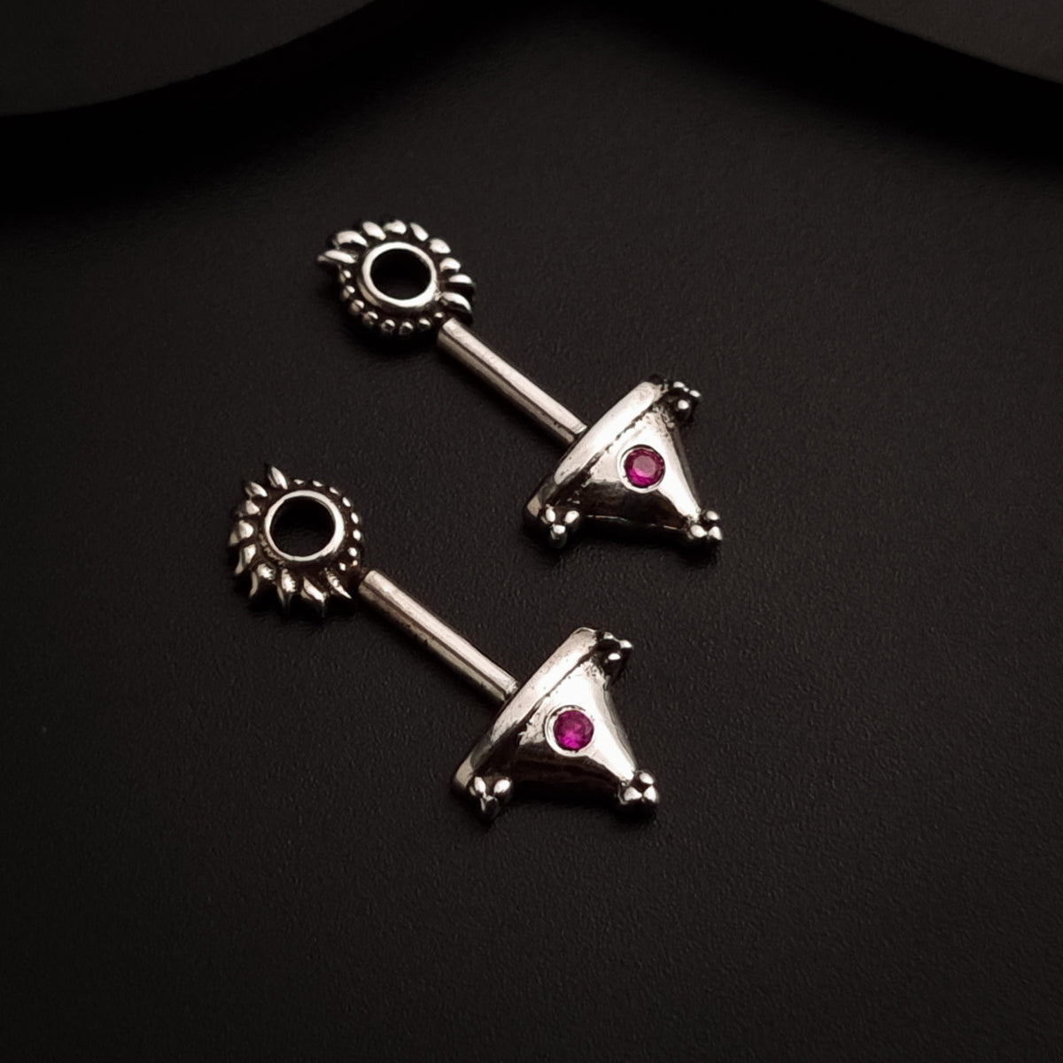a pair of silver earrings with pink stones
