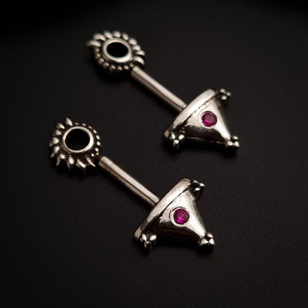 a pair of silver colored earrings with a black stone