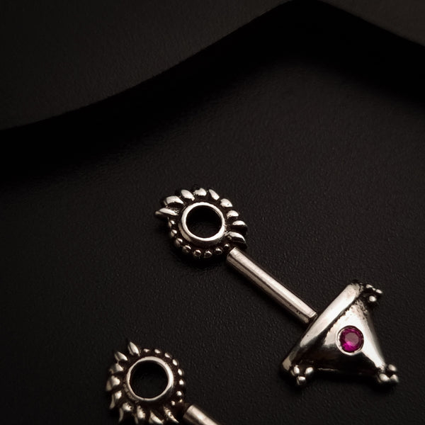 a pair of silver earrings with a pink stone