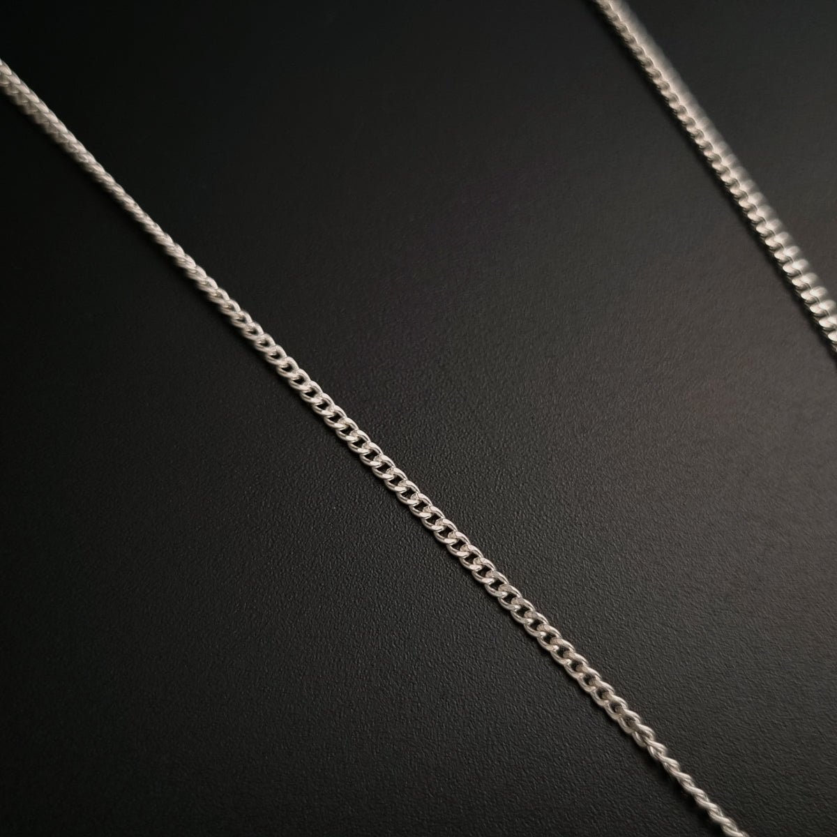a close up of a chain on a black surface