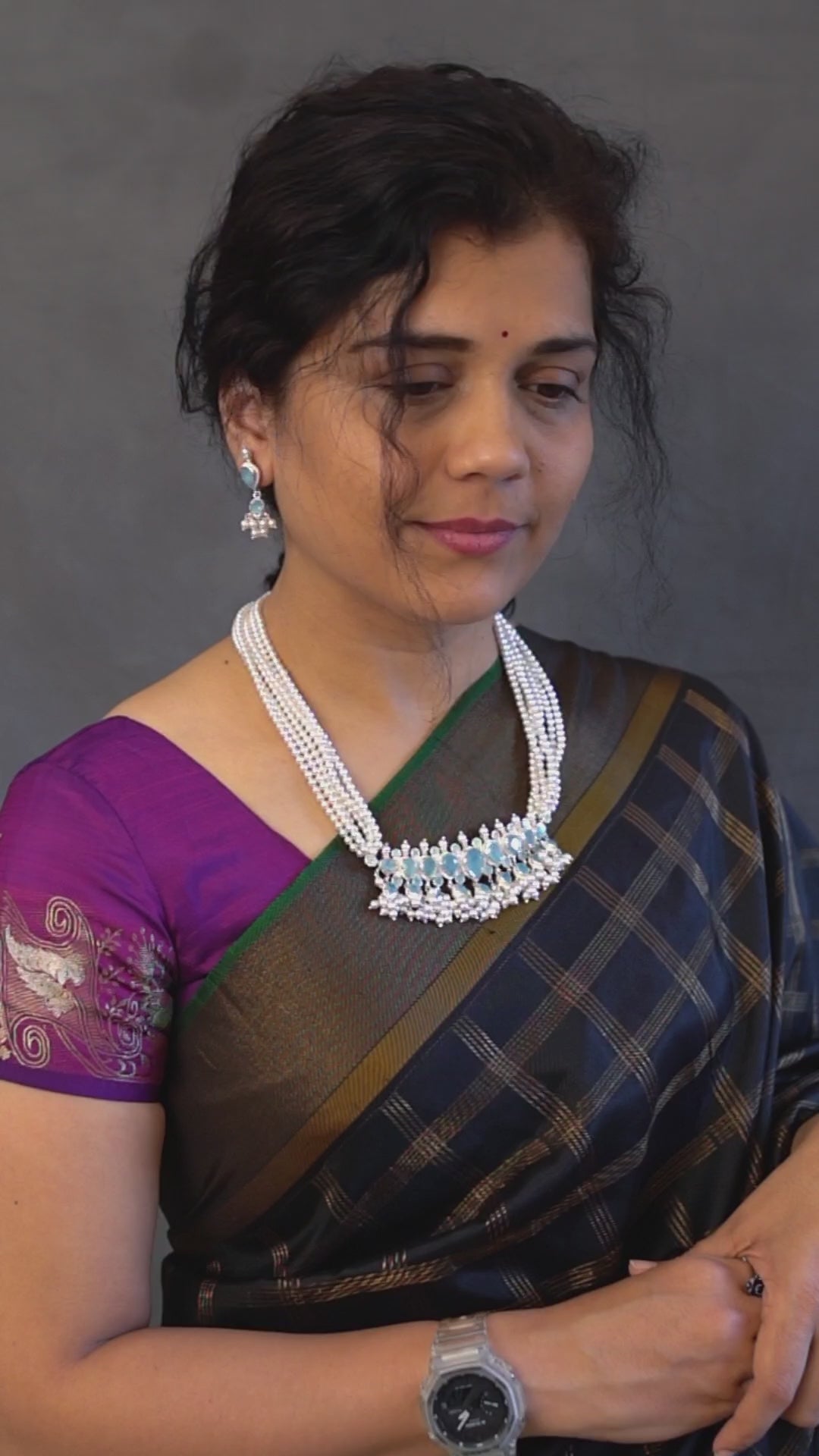 a woman wearing a black and purple saree
