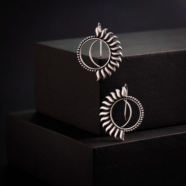 a pair of earrings sitting on top of a black box