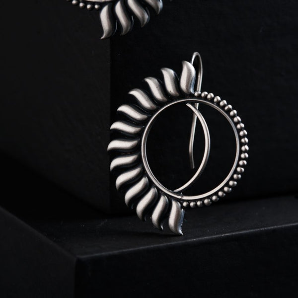 a pair of earrings sitting on top of a black box