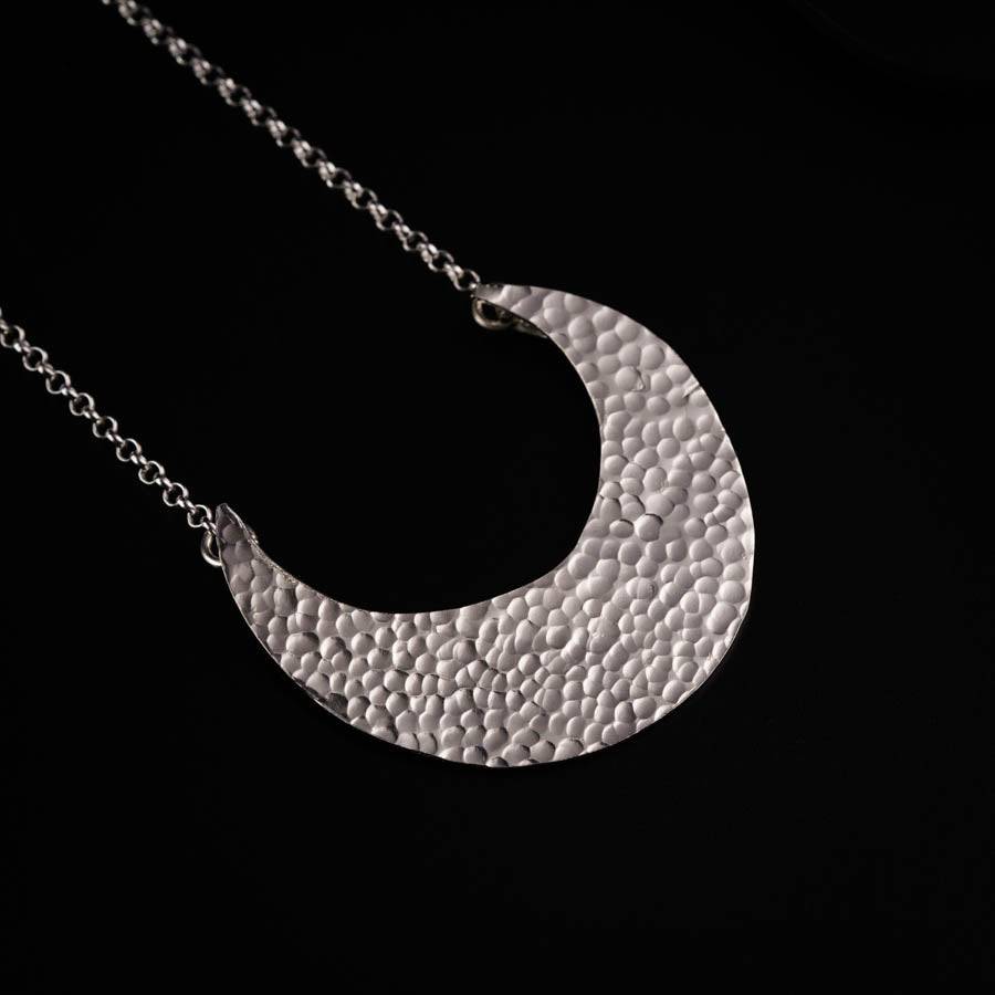 a silver necklace with a circular design on it