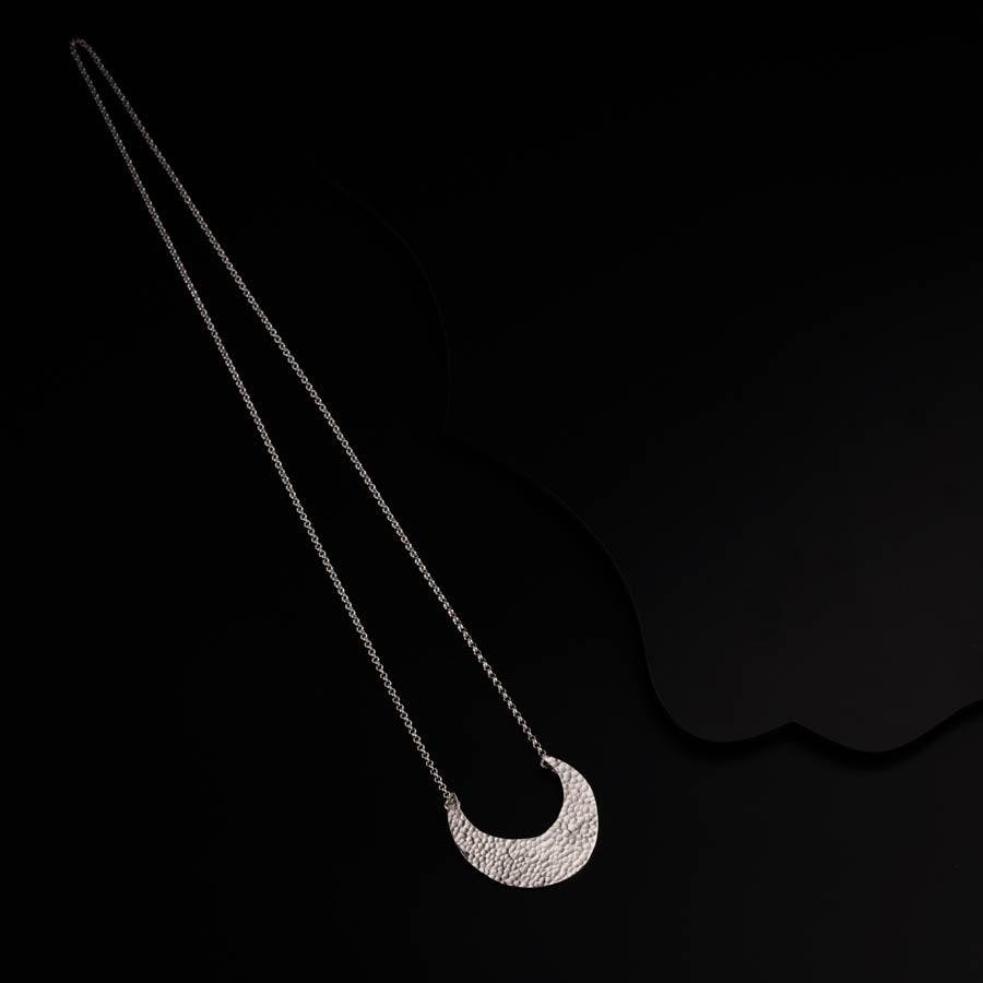 a necklace with a crescent on a black background