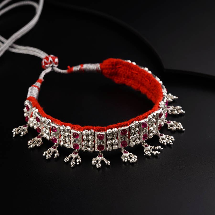 a red string bracelet with silver beads