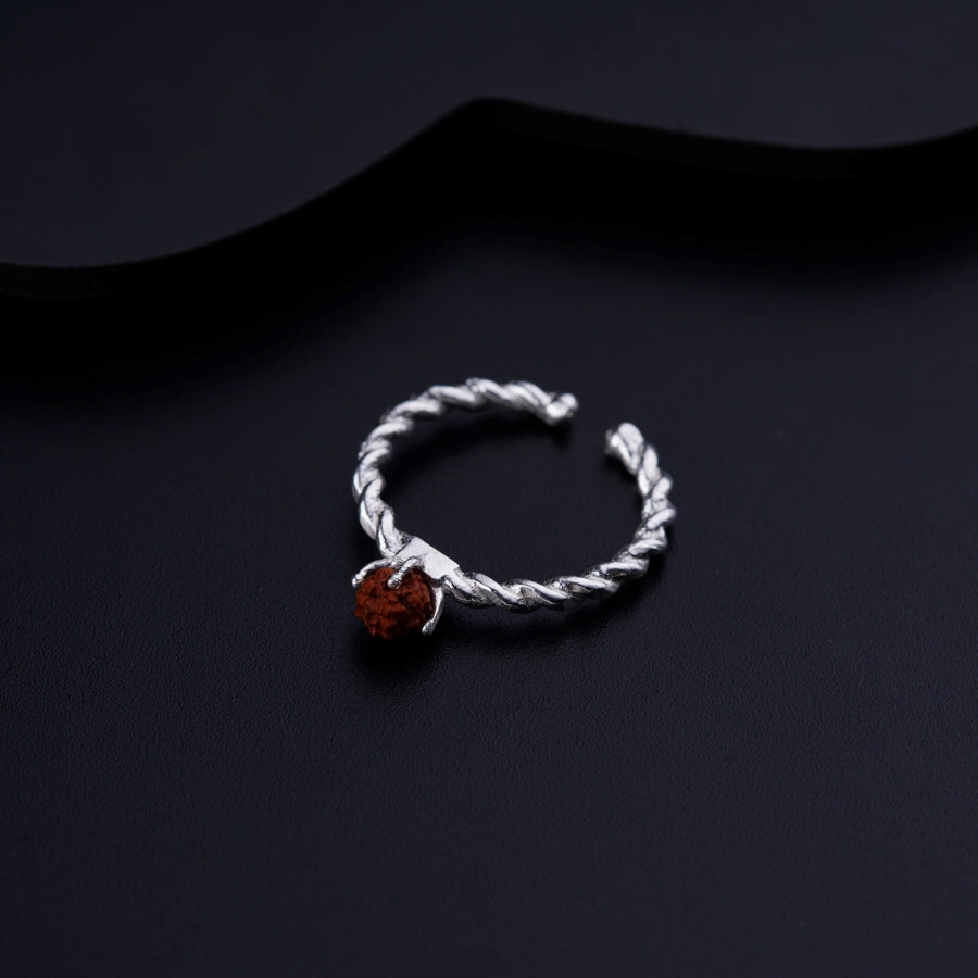 a silver rope ring with a red stone