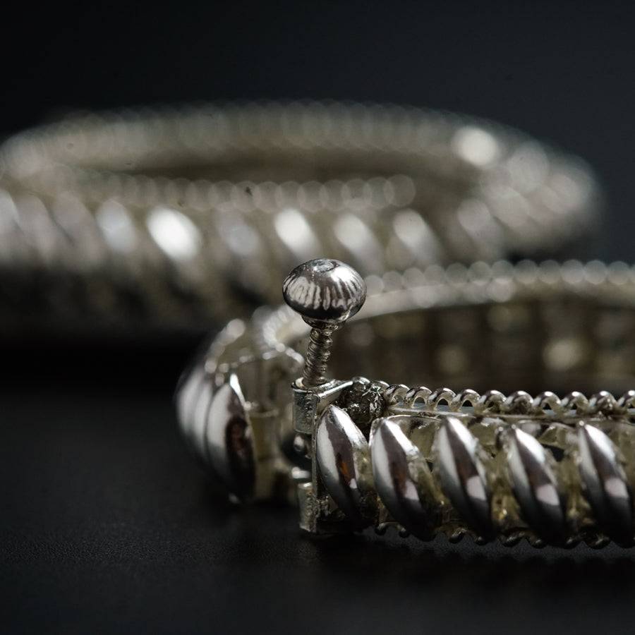 a pair of silver bracelets sitting on top of a table