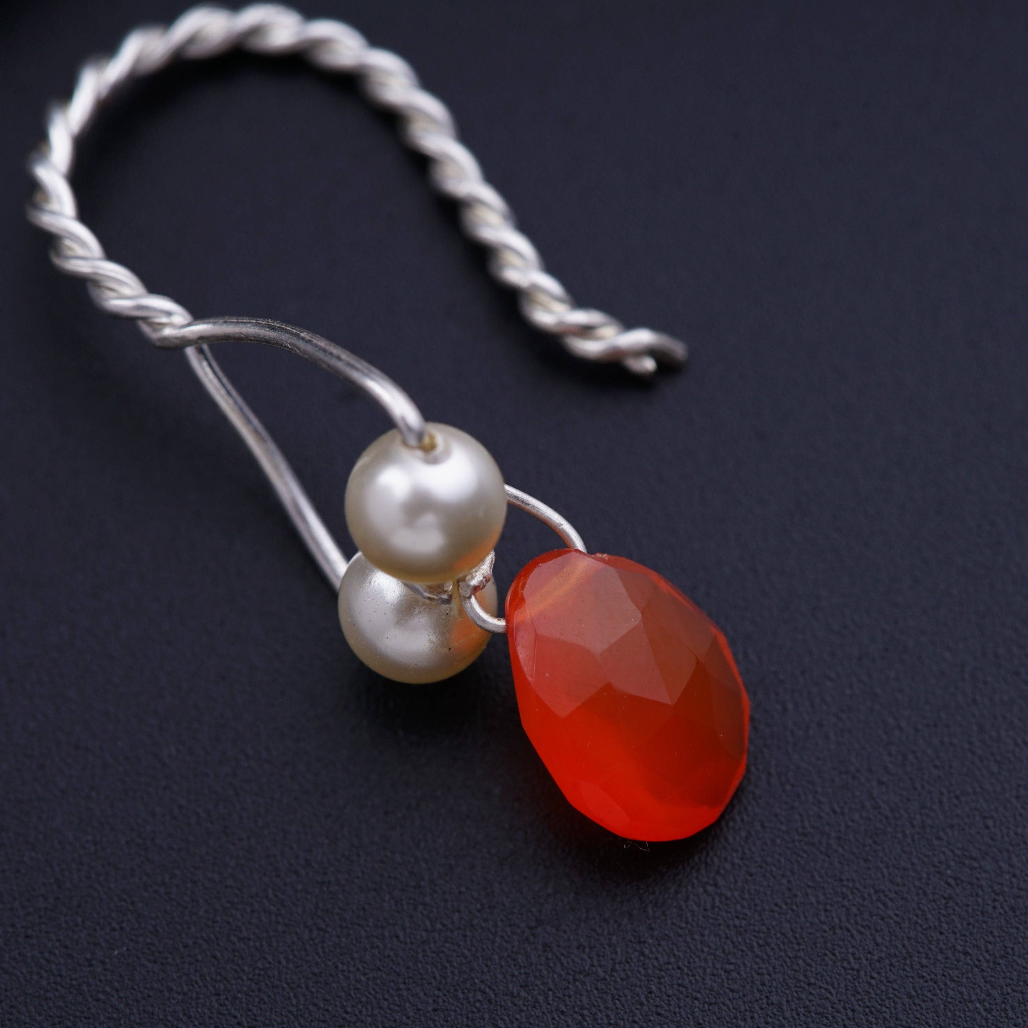 a pair of red and white pearls on a silver chain