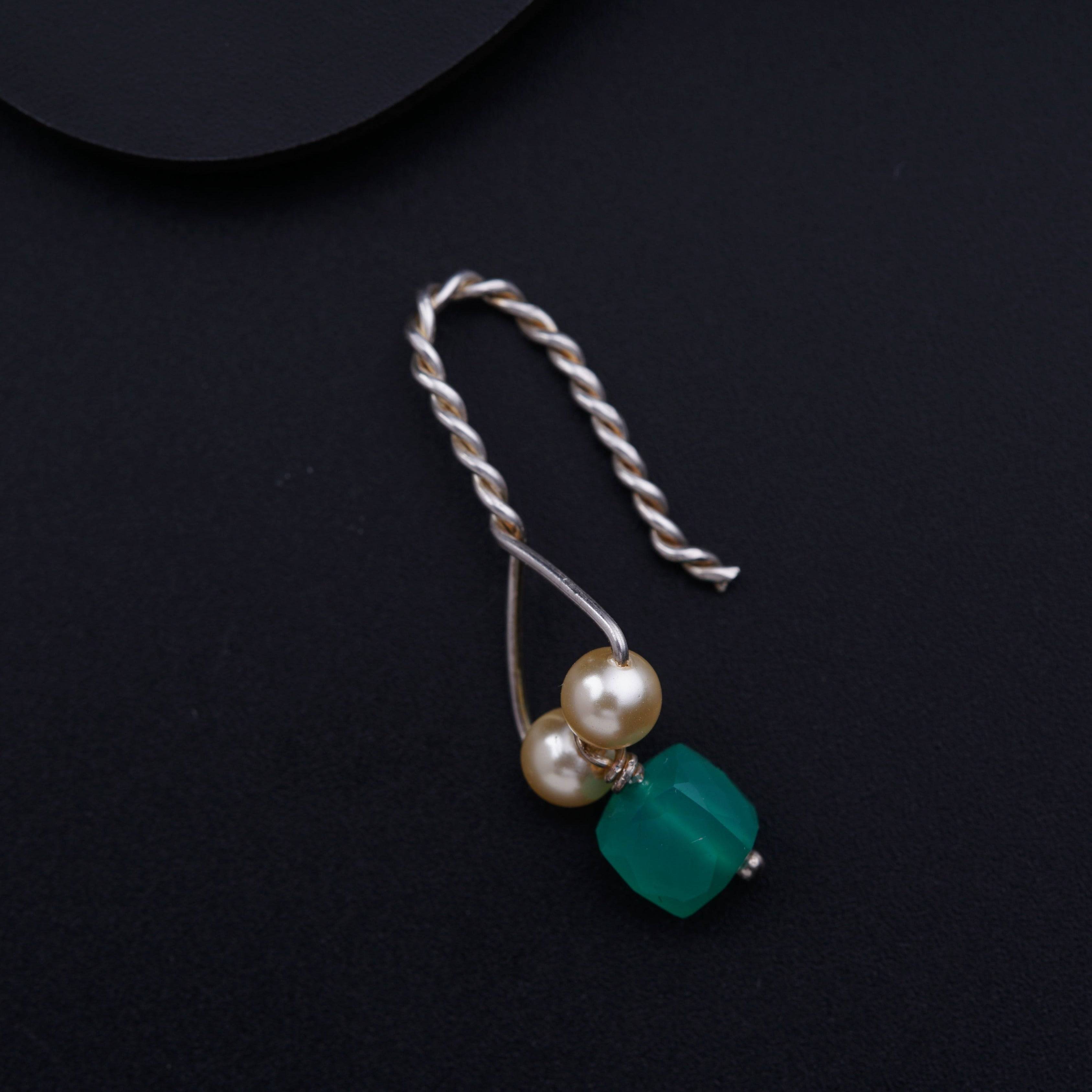 a necklace with pearls and a green bead