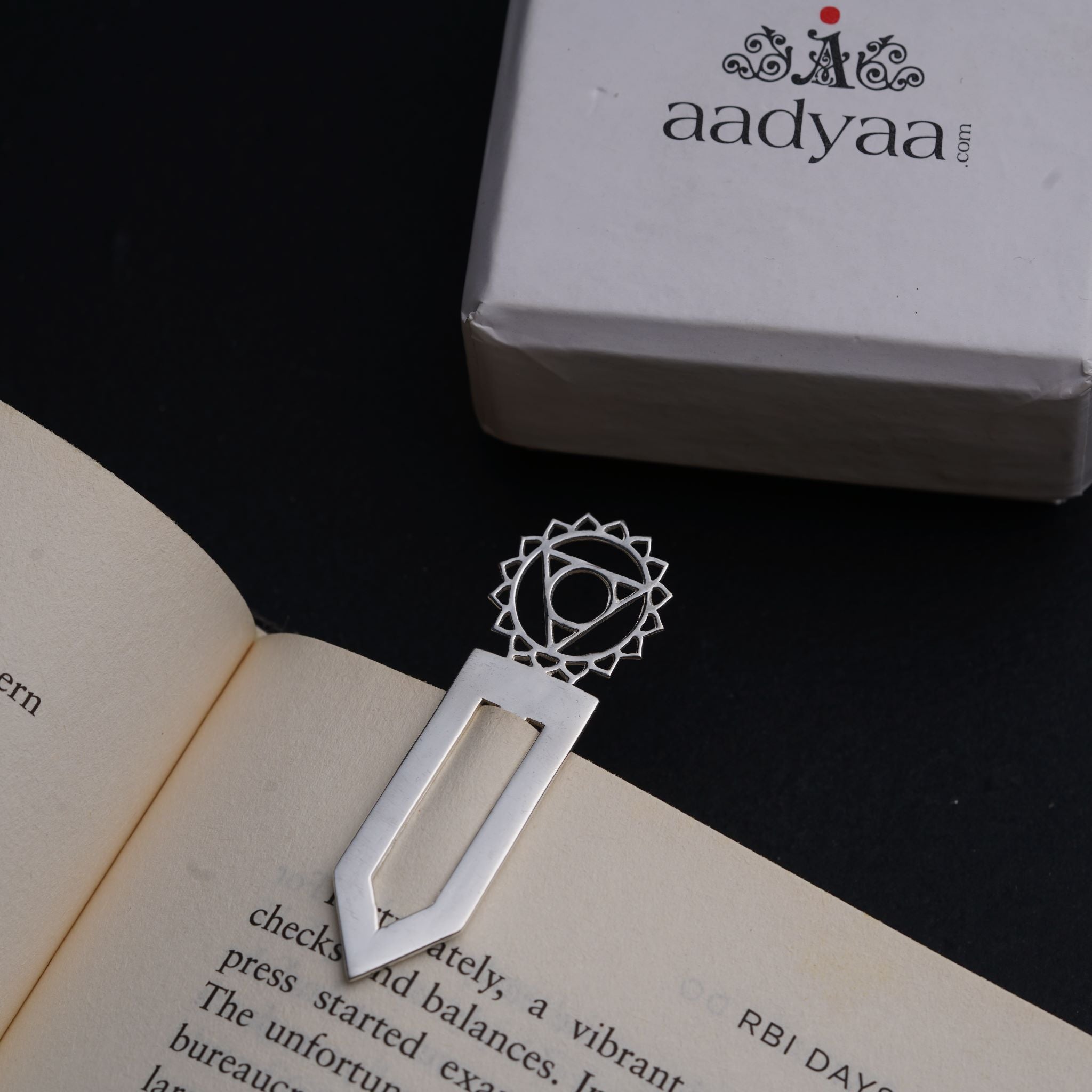a book with a bookmark and a box on a table
