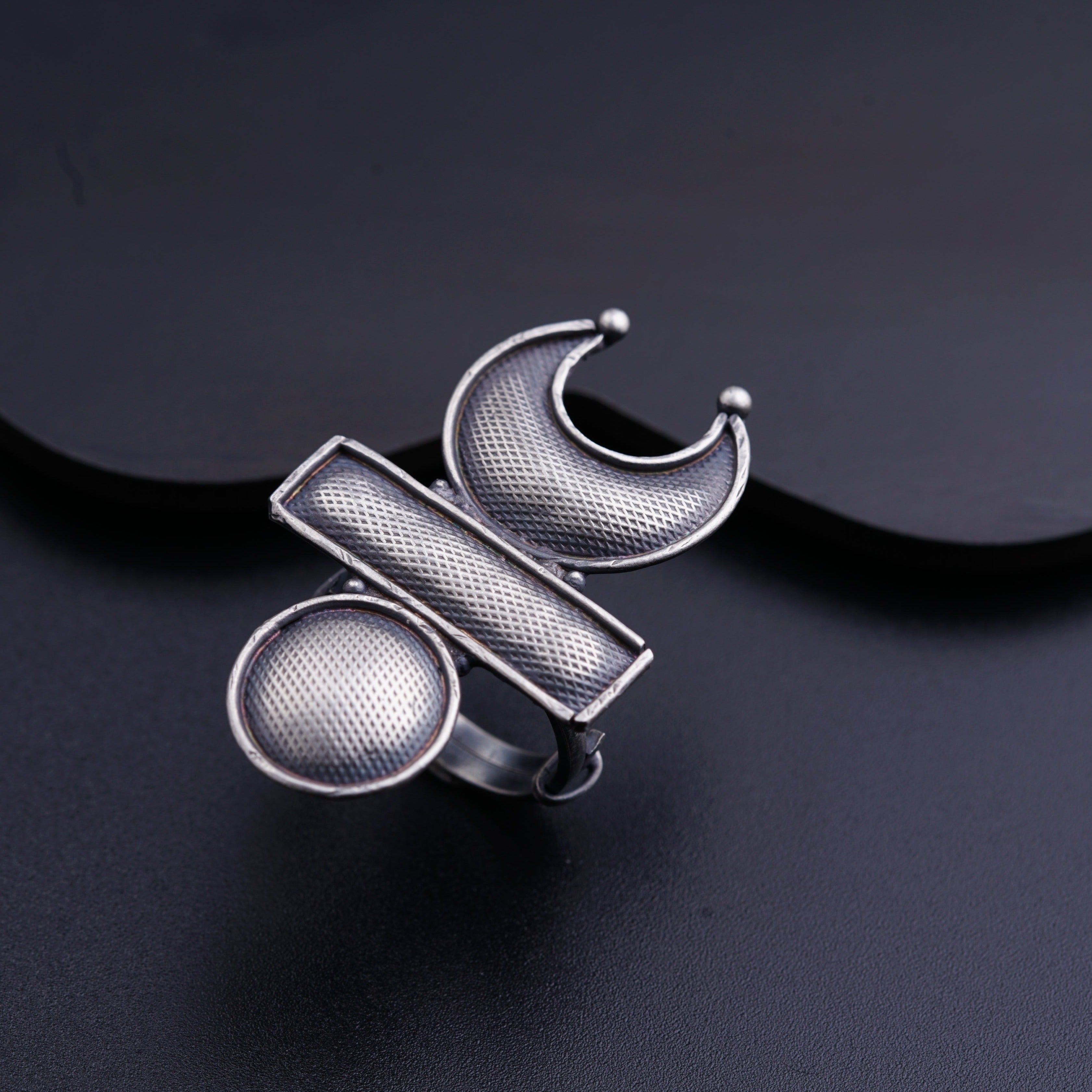 a silver ring sitting on top of a black surface