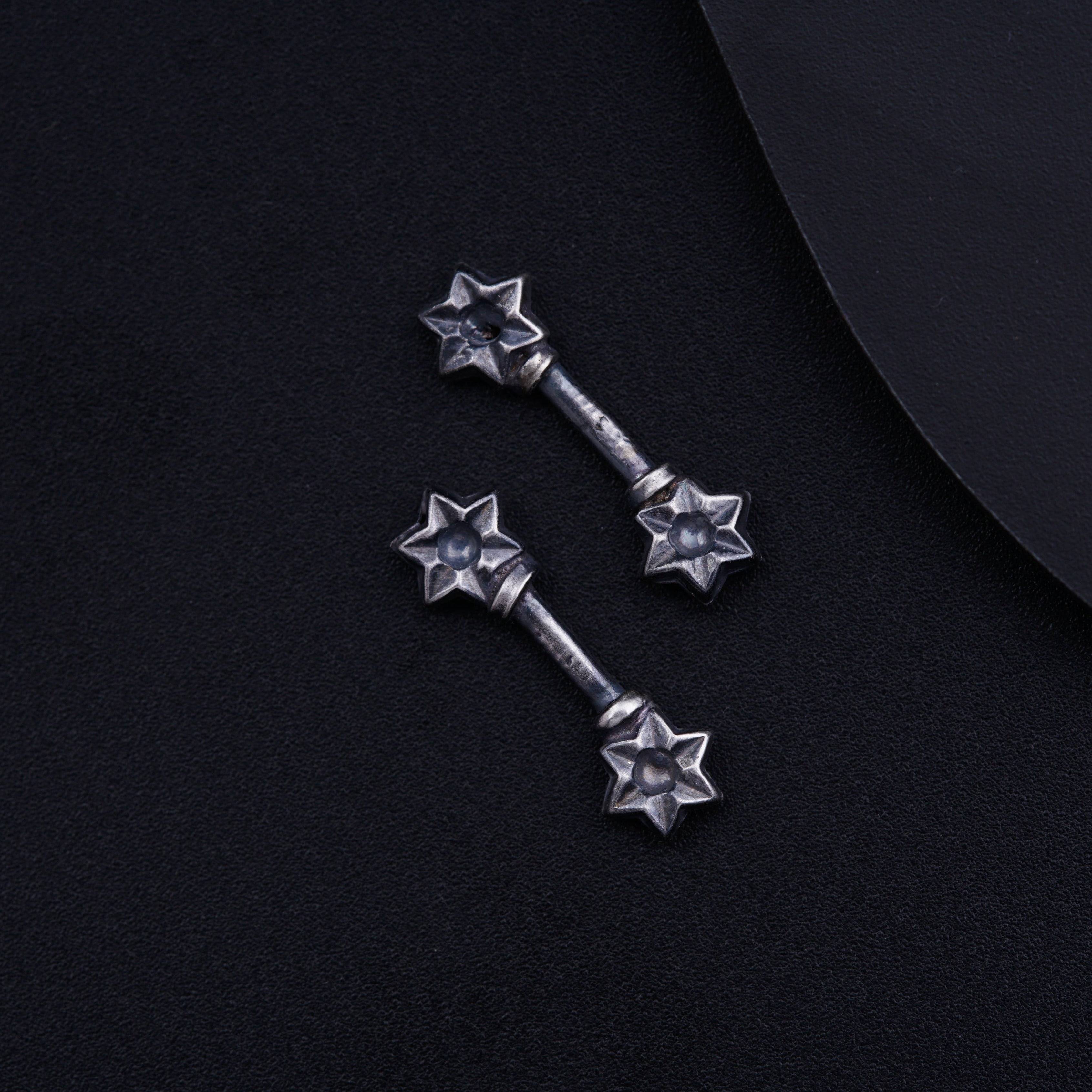 a pair of metal stars on a black background