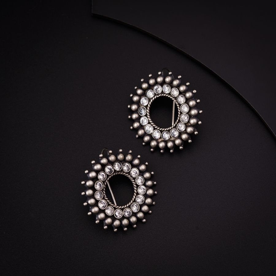 a pair of earrings on a black surface