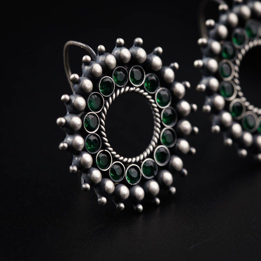 a close up of a pair of earrings on a black surface