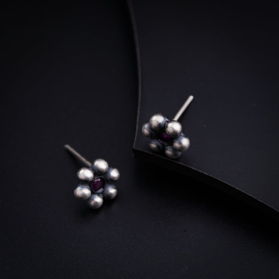 a pair of earrings with pearls on a black background
