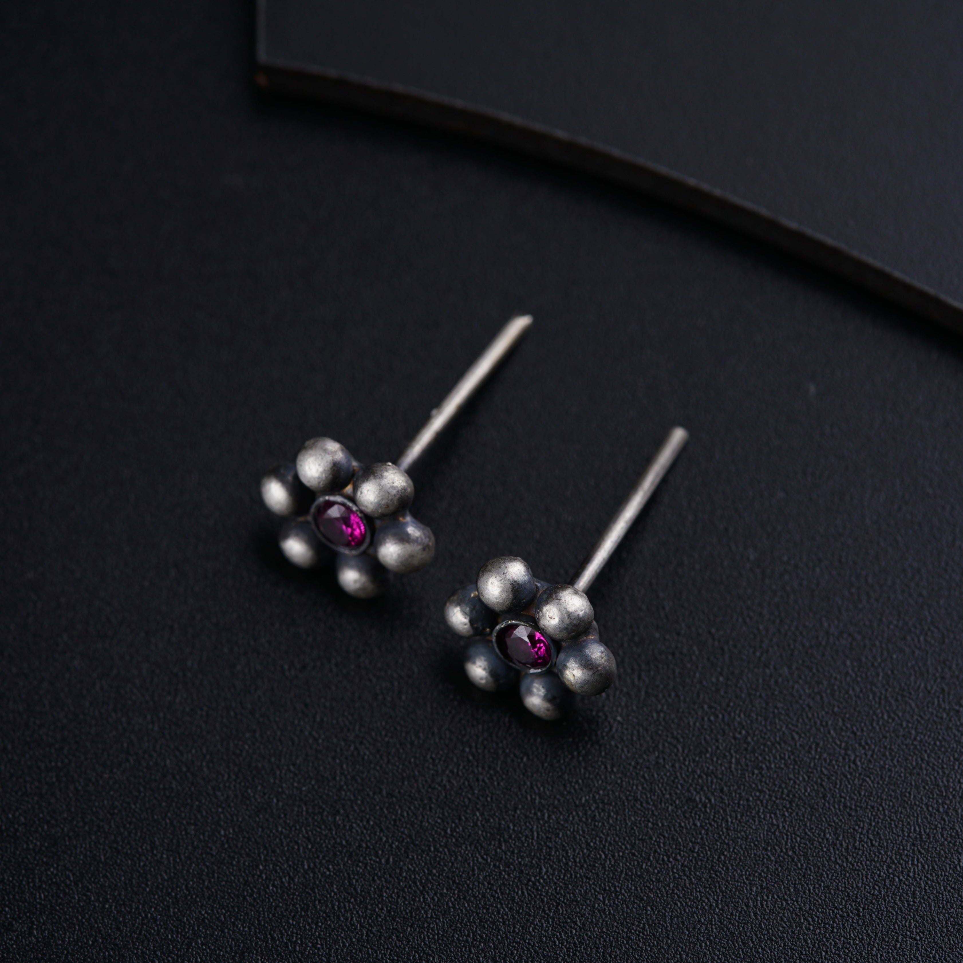 a pair of silver earrings with pink stones