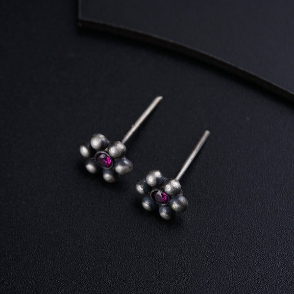 a pair of silver earrings with pink stones