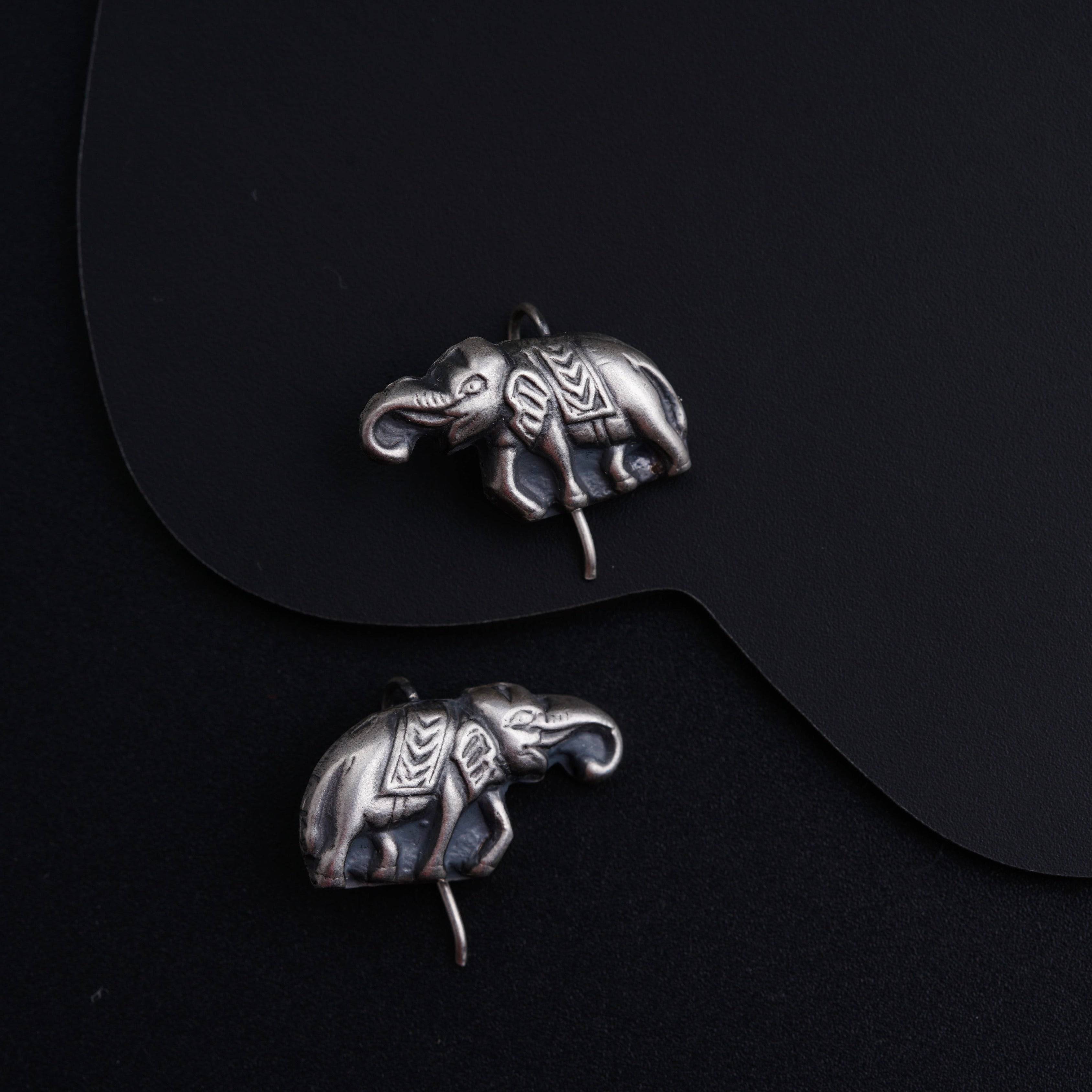 a pair of silver elephants sitting on top of a table