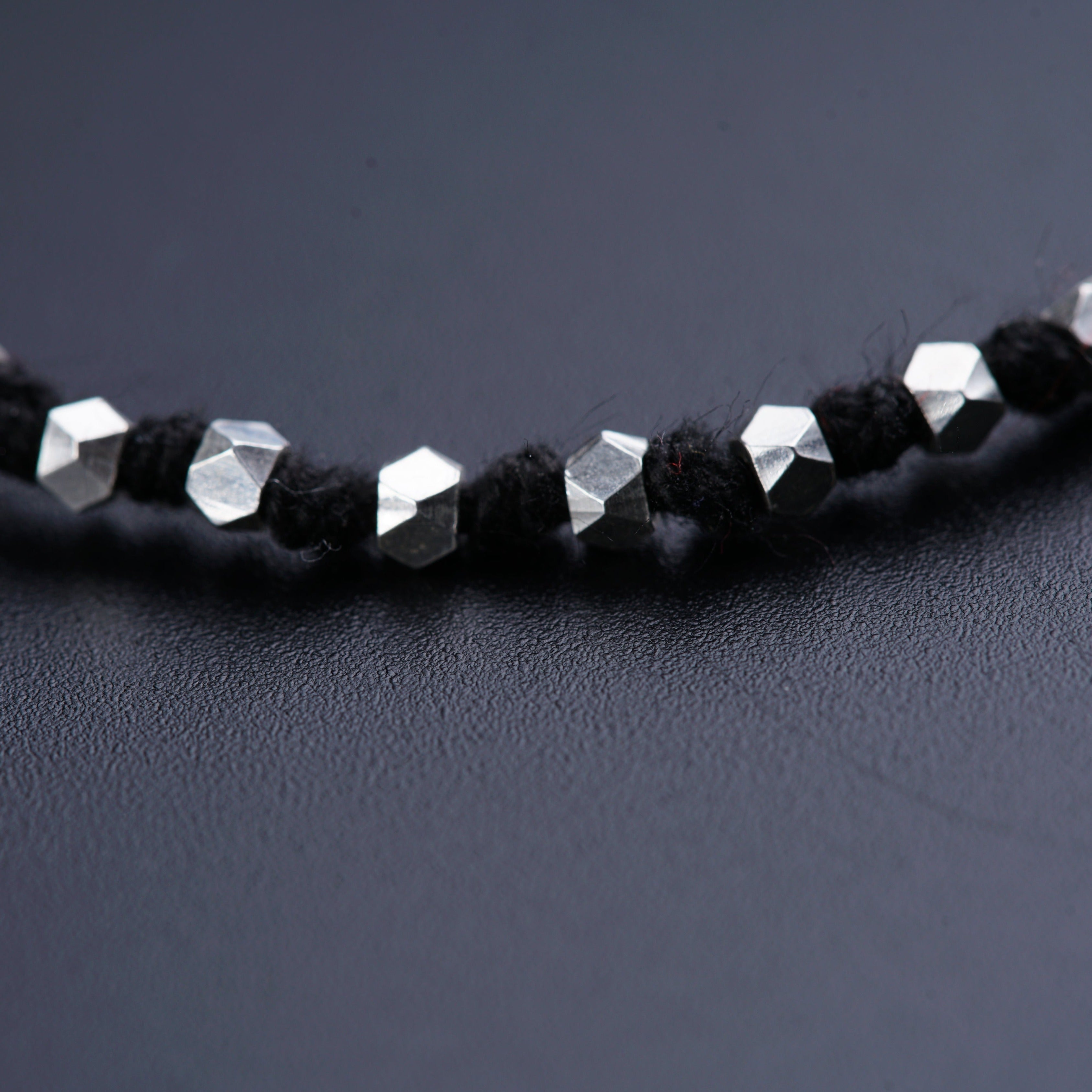 a close up of a necklace on a black surface