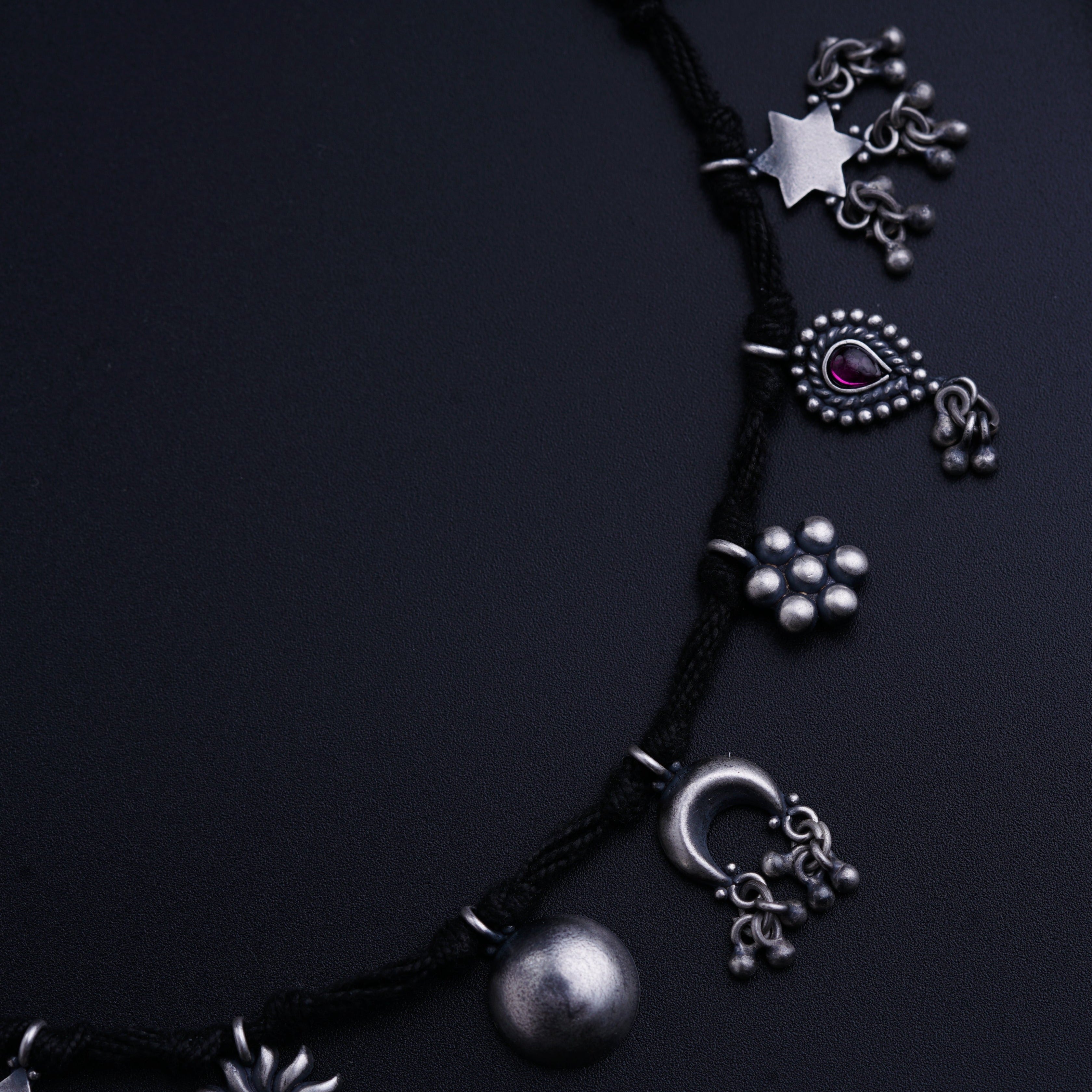 a close up of a necklace on a black surface