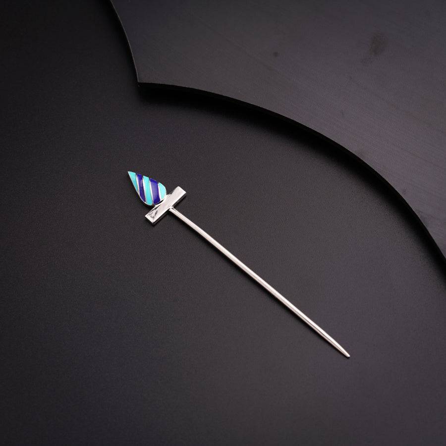 a blue and white striped toothpick on a black surface