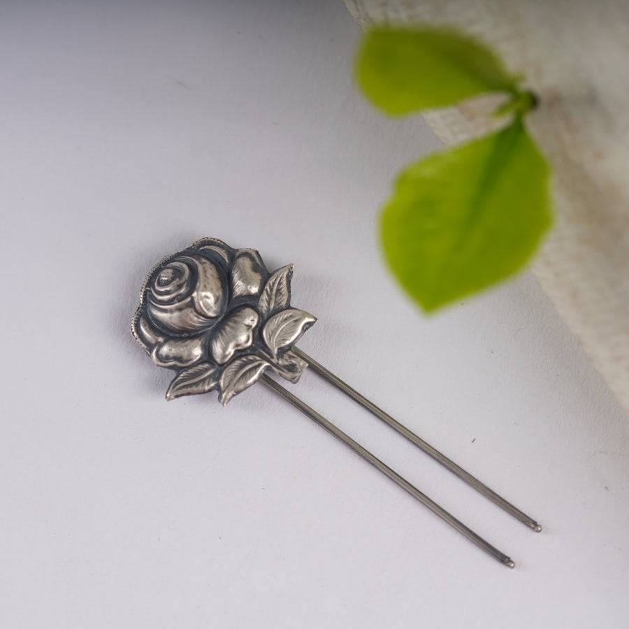 a close up of a flower brooch on a white surface
