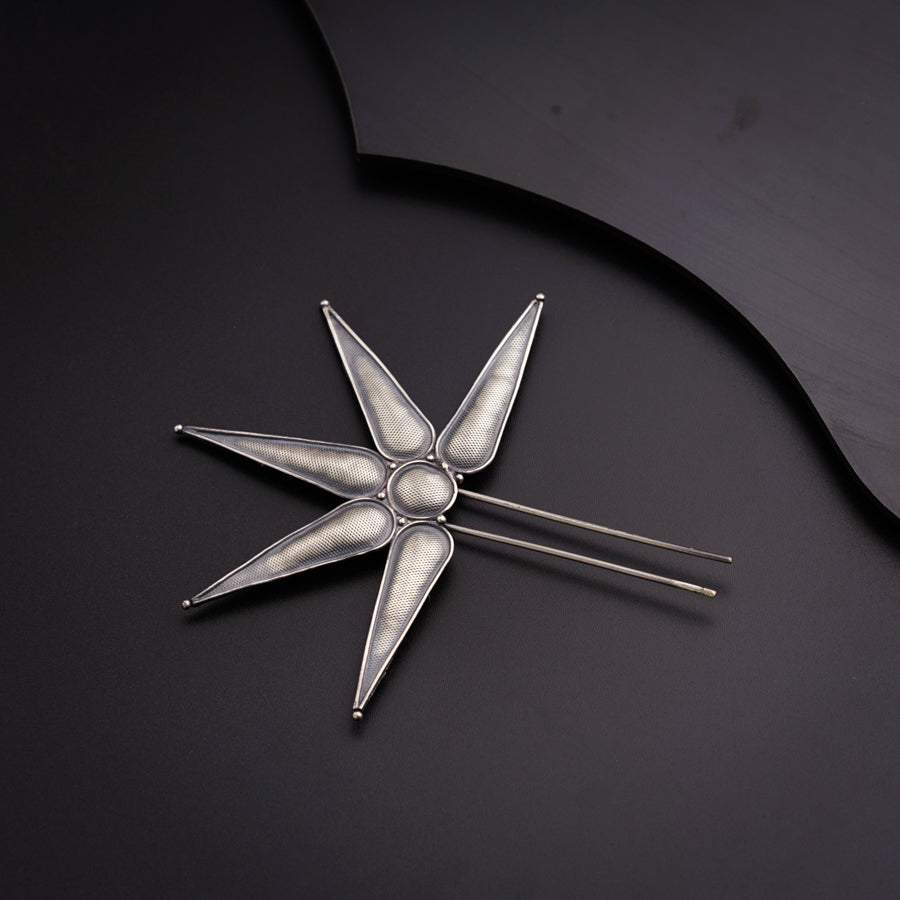 a silver pin with a star design on it