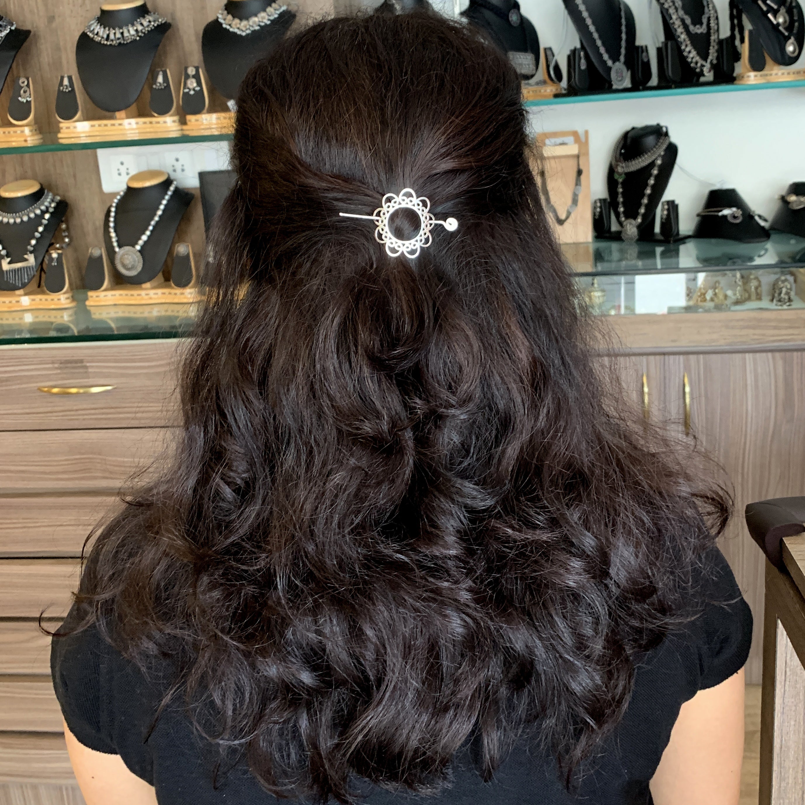a woman with long dark hair wearing a hair clip