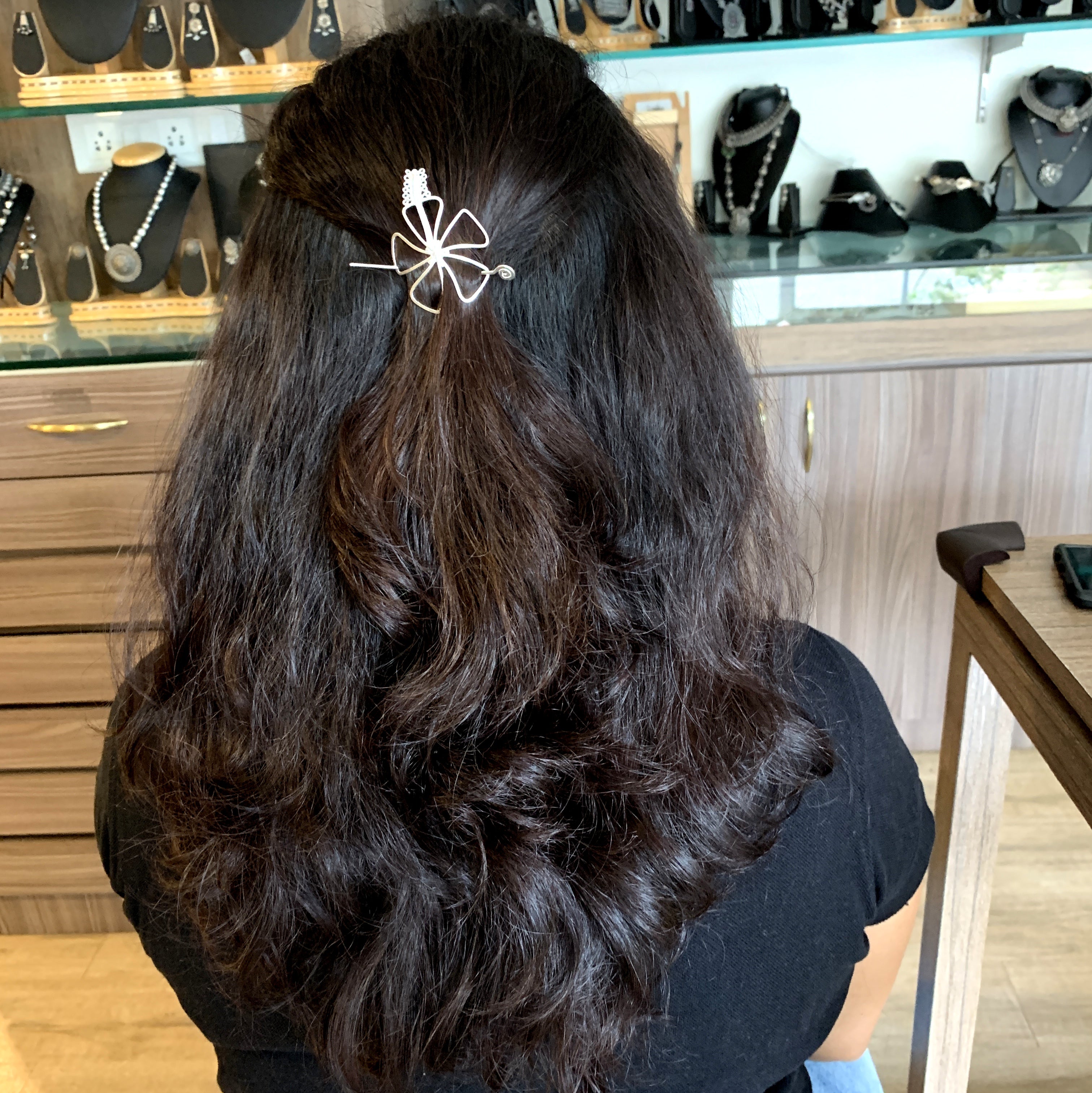 a woman sitting at a table with a hair clip in her hair