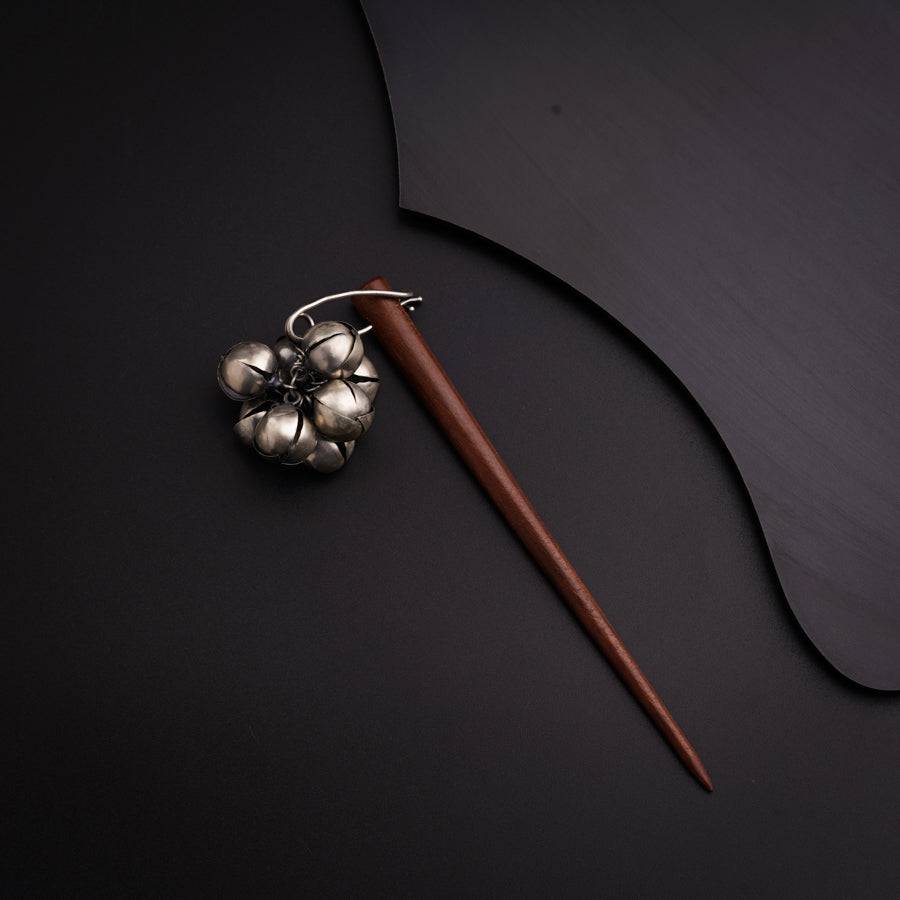 a metal object with a wooden handle on a black surface