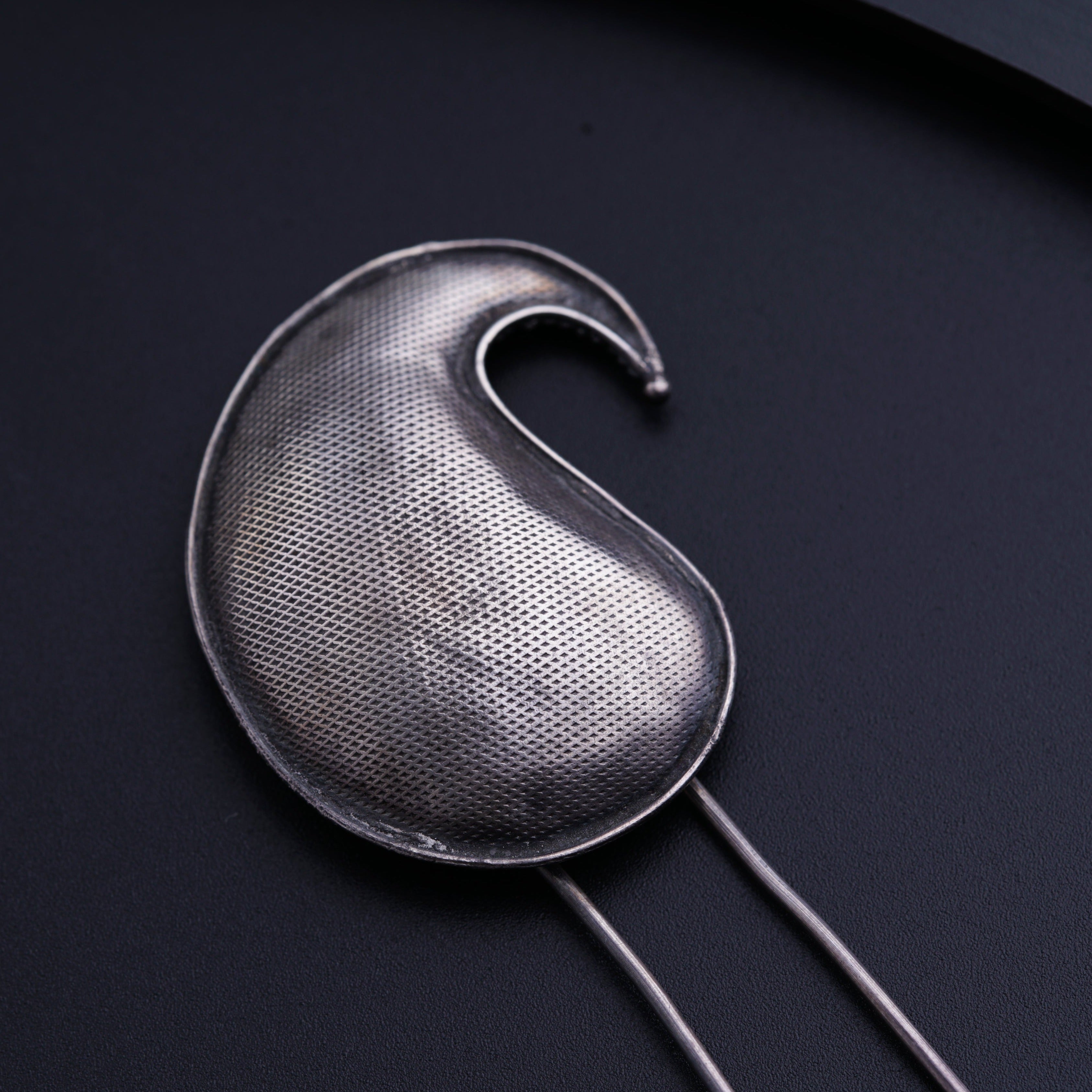 a close up of a metal object on a black surface