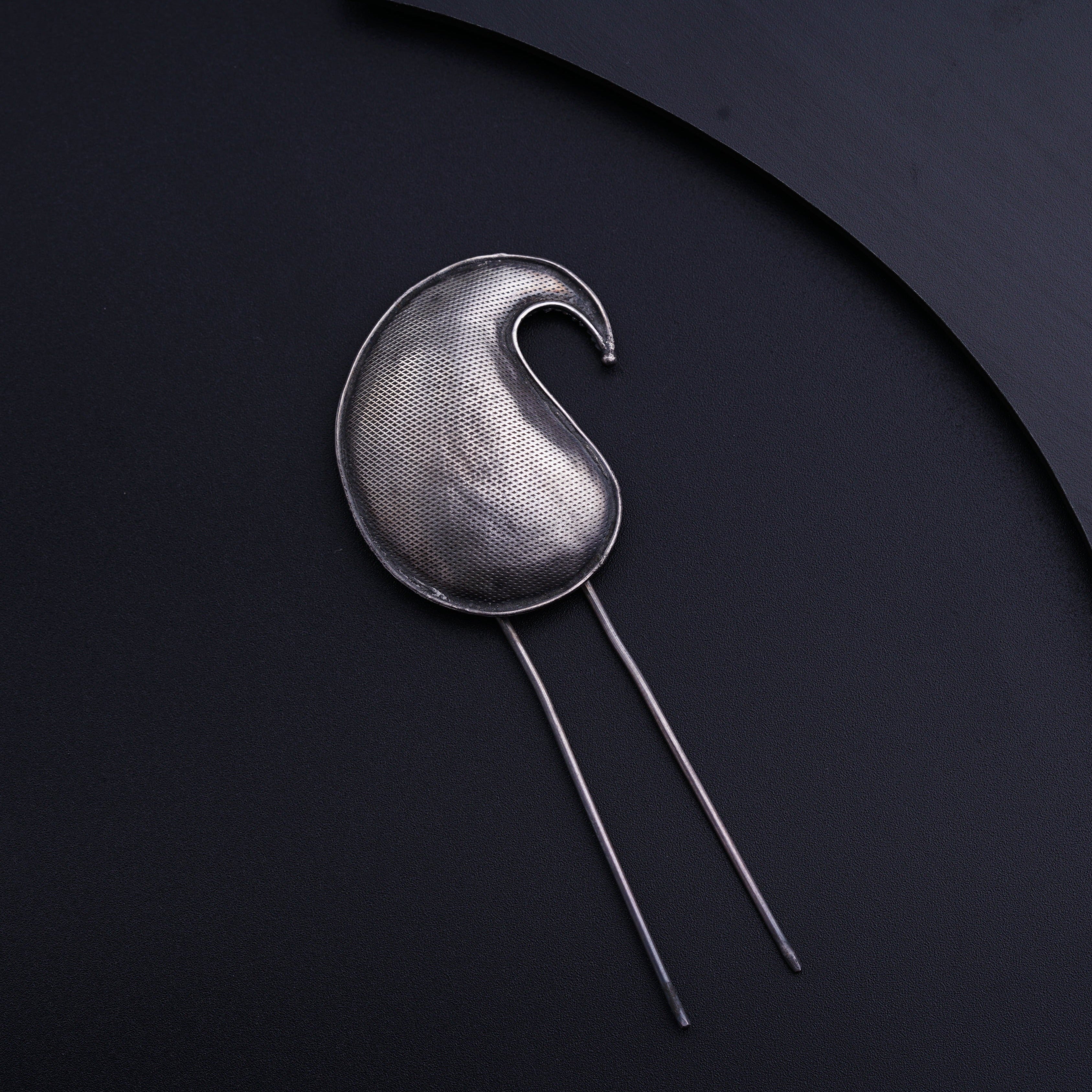 a metal object on a black surface