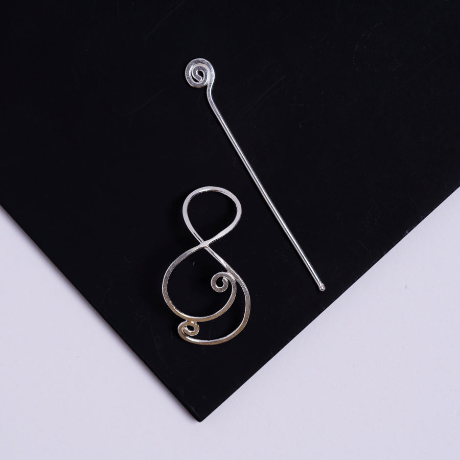 a pair of silver ear wires on a black surface