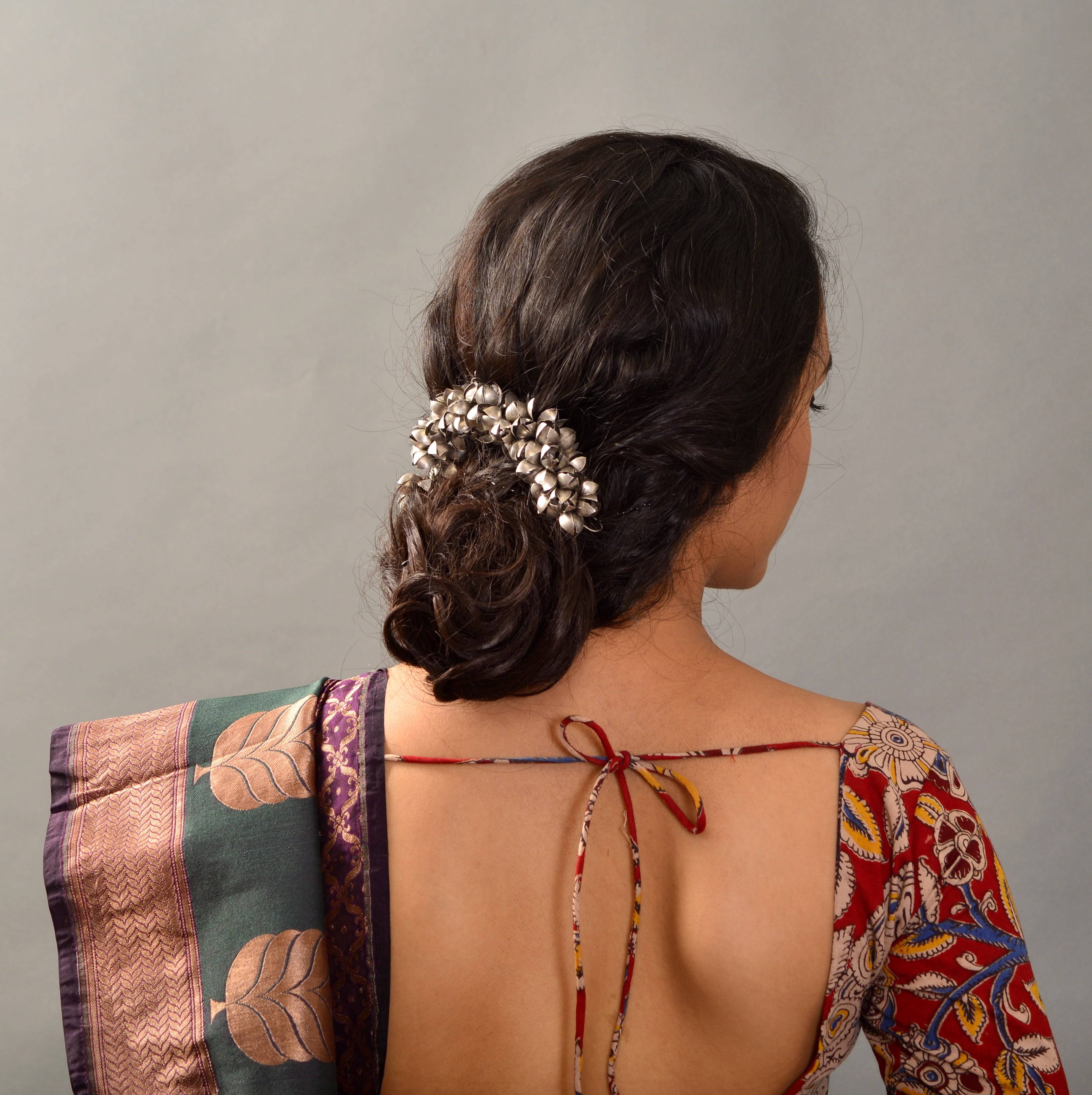 a woman in a colorful sari with a flower in her hair