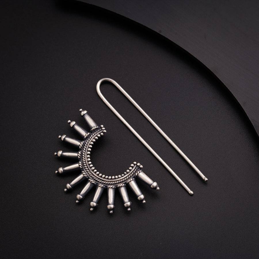 a pair of earrings and a pair of needles