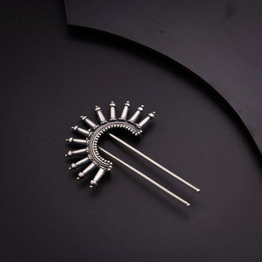 a pair of pins sitting on top of a black surface