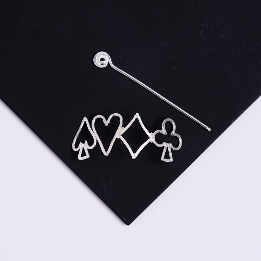 a pair of earrings sitting on top of a black piece of paper