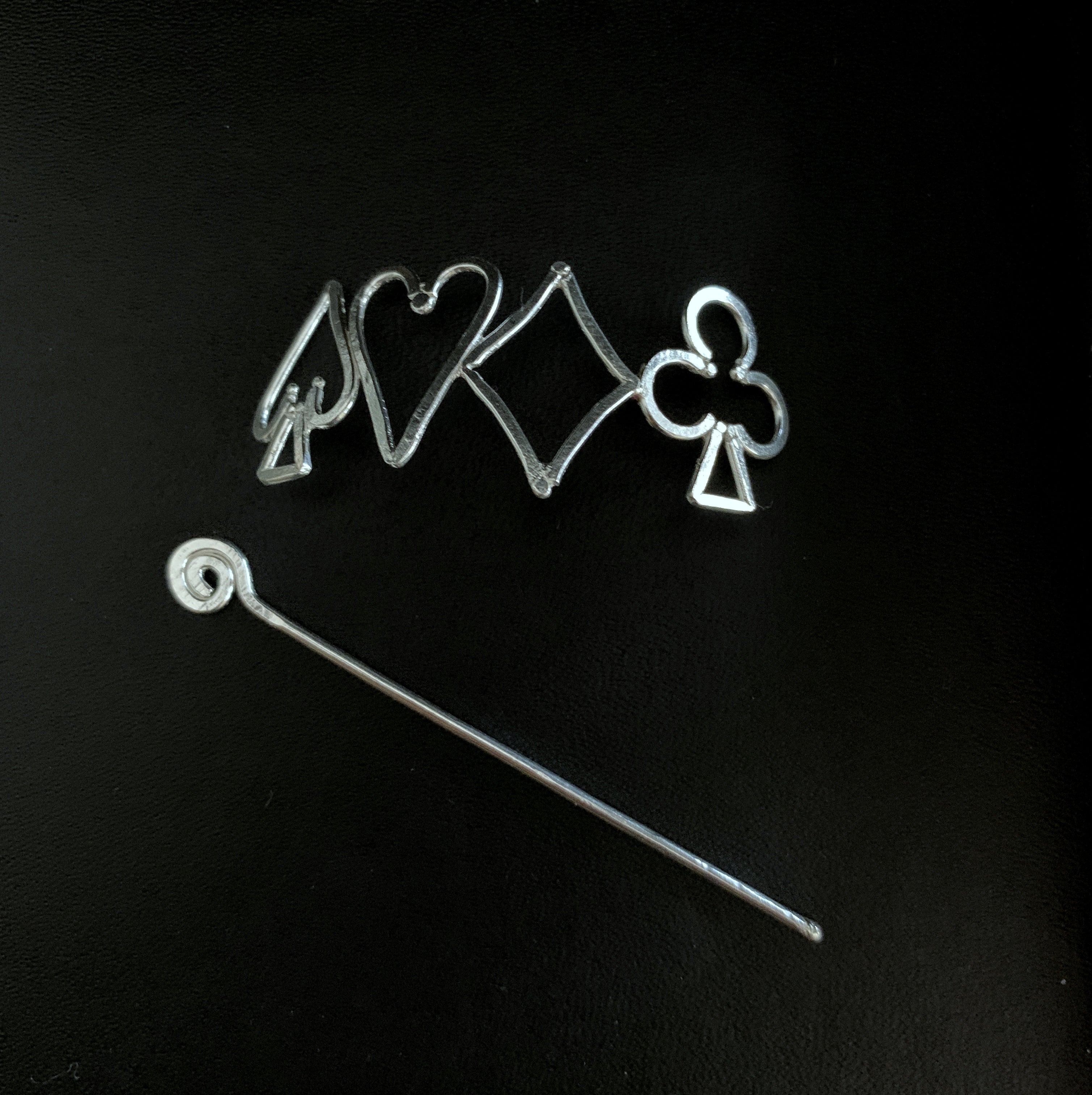 a pair of scissors and a piece of wire on a black surface